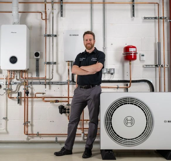 Installer standing in front of Worcester Bosch products